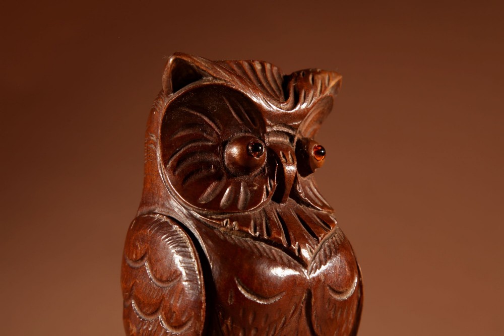 A pair of hand-carved dark wood owl figures with glass eyes mounted on carved wooden bases. View XI