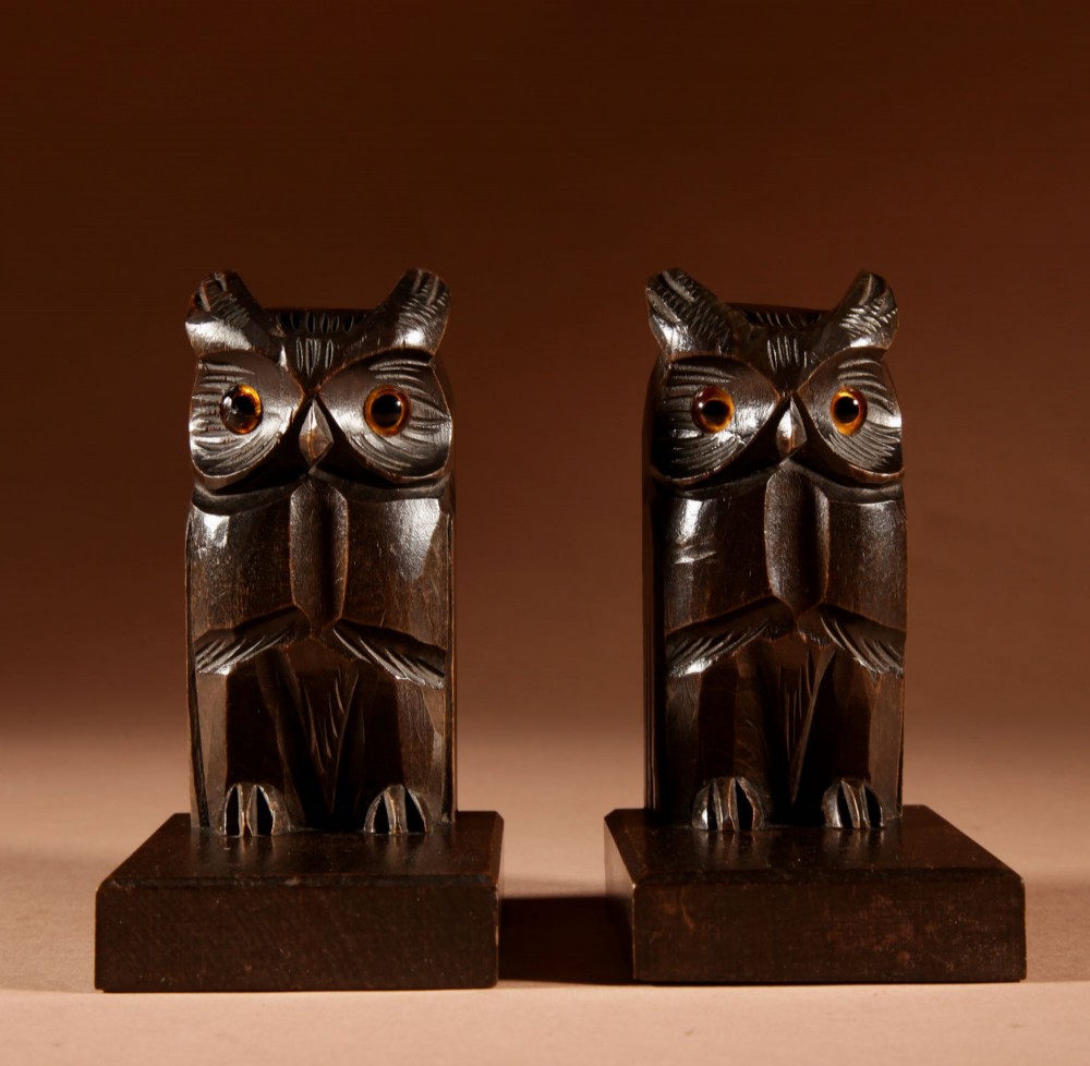 A pair of hand-carved dark wood owl bookends with inset glass eyes, standing on rectangular wooden bases. View II