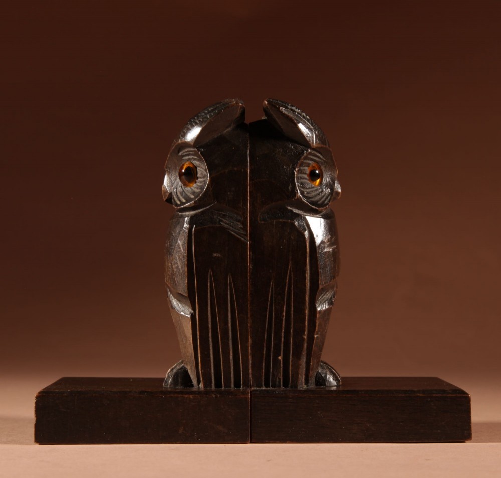 A pair of hand-carved dark wood owl bookends with inset glass eyes, standing on rectangular wooden bases. View III