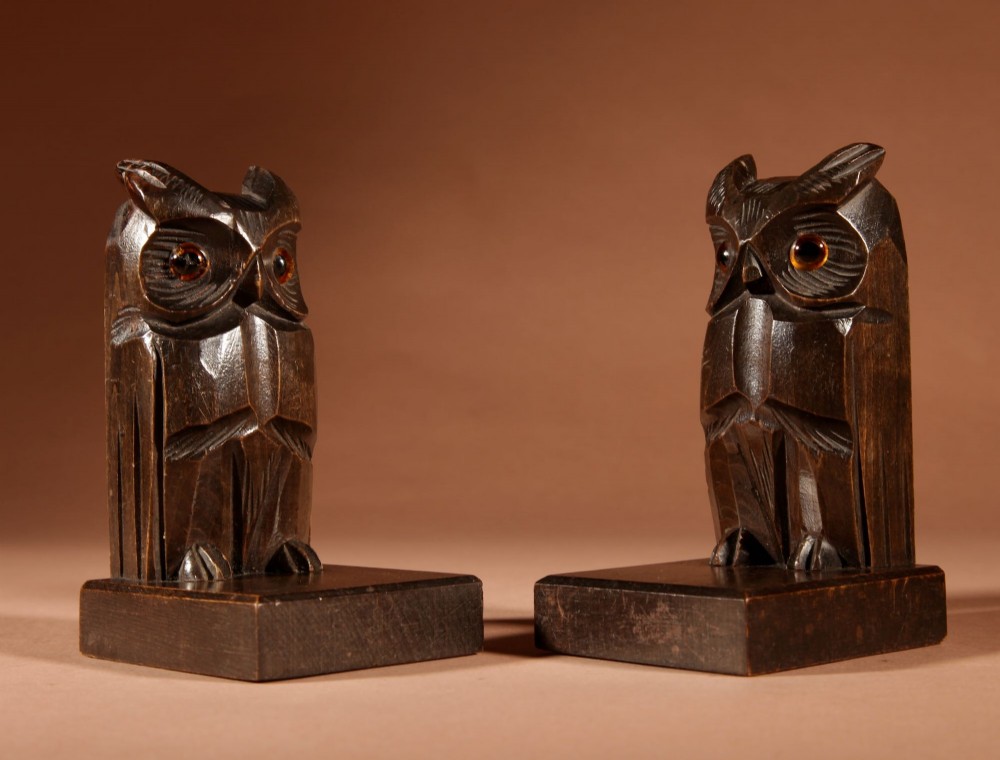 A pair of hand-carved dark wood owl bookends with inset glass eyes, standing on rectangular wooden bases. View V