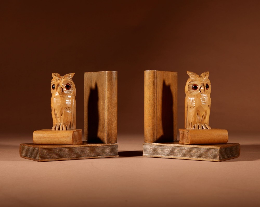 A pair of carved wooden owl bookends positioned on bases shaped like stacked books with amber glass eyes. View IV