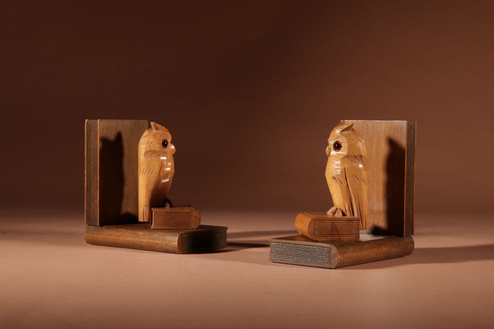 A pair of carved wooden owl bookends positioned on bases shaped like stacked books with amber glass eyes. View V