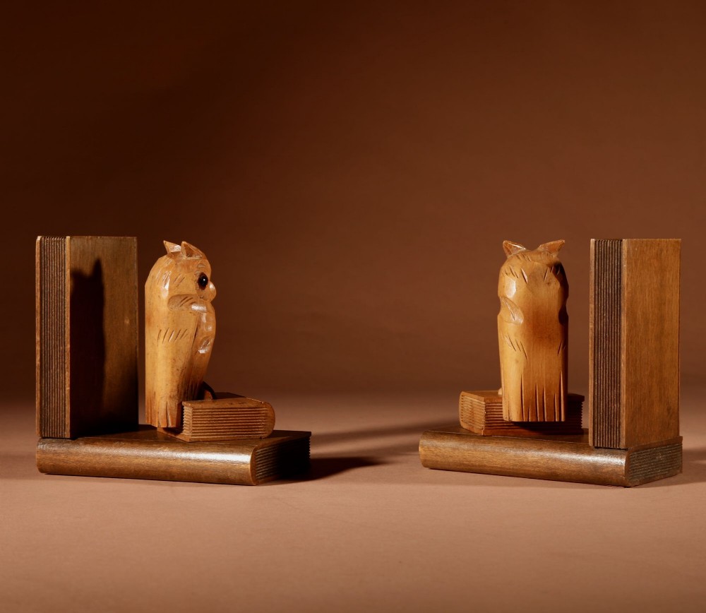 A pair of carved wooden owl bookends positioned on bases shaped like stacked books with amber glass eyes. View VI