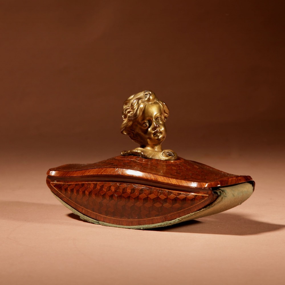 A nineteenth-century French rocker blotter featuring geometric wood parquetry inlay, a green felt underside, and a sculpted gilt bronze cherub head handle. View II