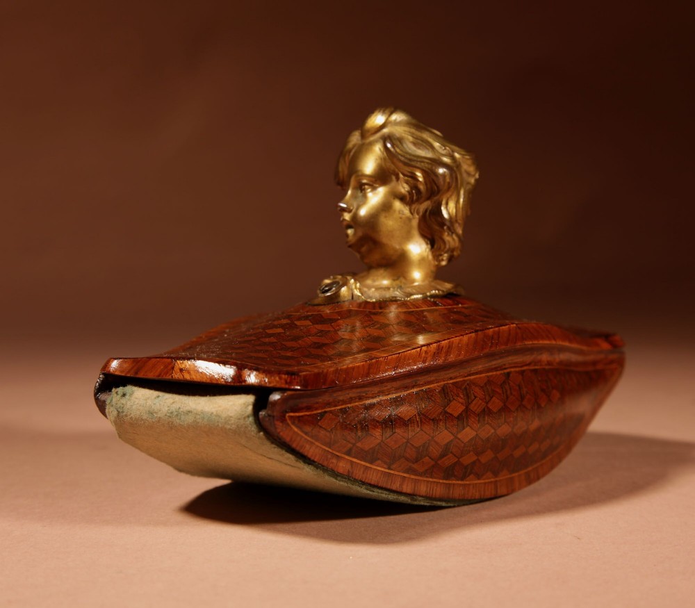 A nineteenth-century French rocker blotter featuring geometric wood parquetry inlay, a green felt underside, and a sculpted gilt bronze cherub head handle. View VII