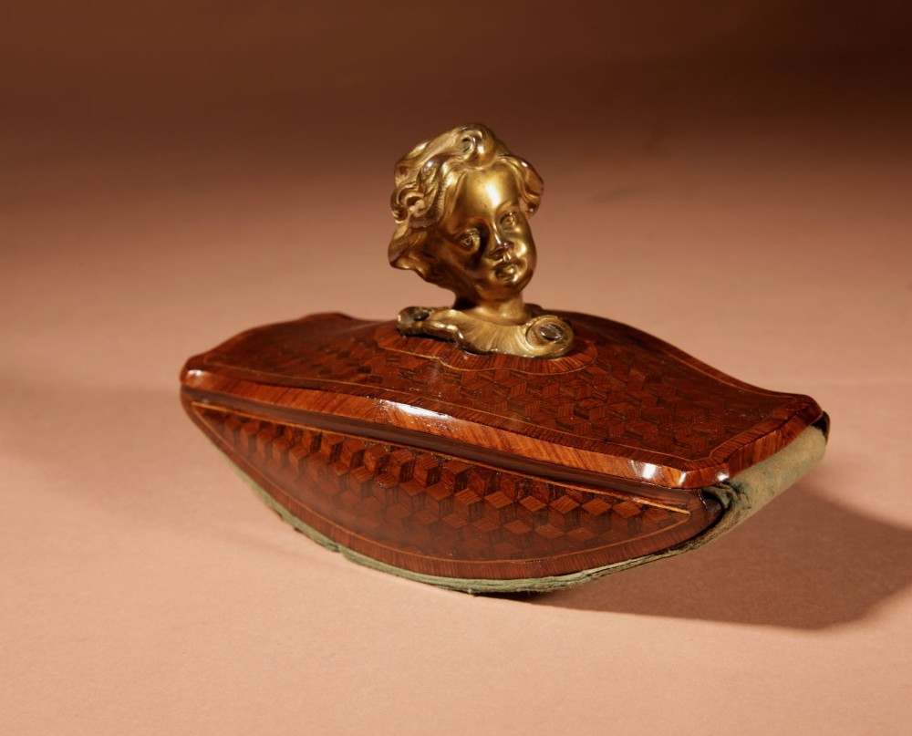 A nineteenth-century French rocker blotter featuring geometric wood parquetry inlay, a green felt underside, and a sculpted gilt bronze cherub head handle. View XIII