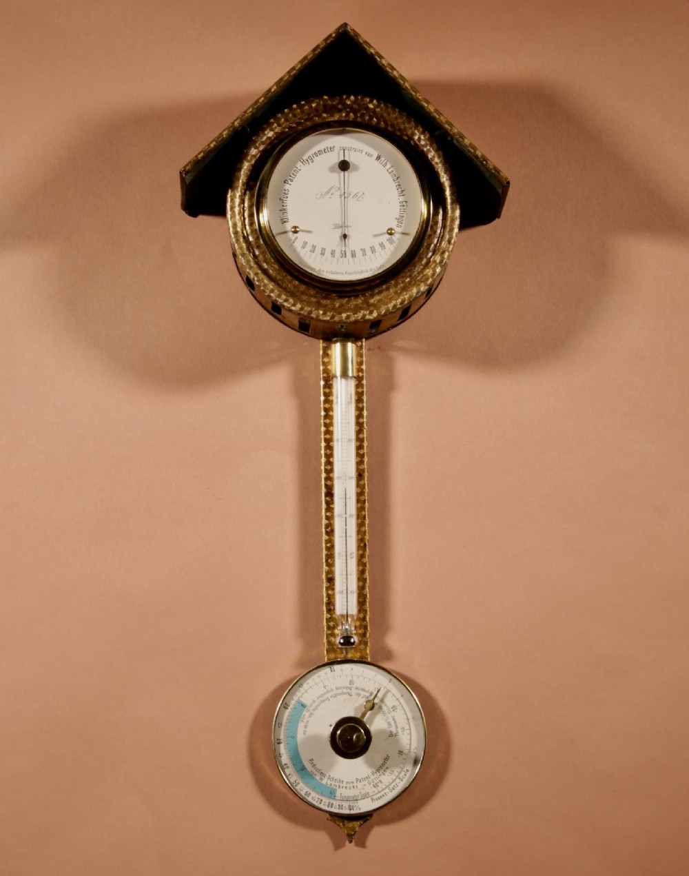 An antique late nineteenth-century brass wall-mounted Klinkerfues patent hair hygrometer weather station featuring two circular dials and a central thermometer tube.