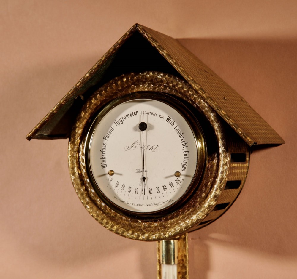 An antique late nineteenth-century brass wall-mounted Klinkerfues patent hair hygrometer weather station featuring two circular dials and a central thermometer tube. View III