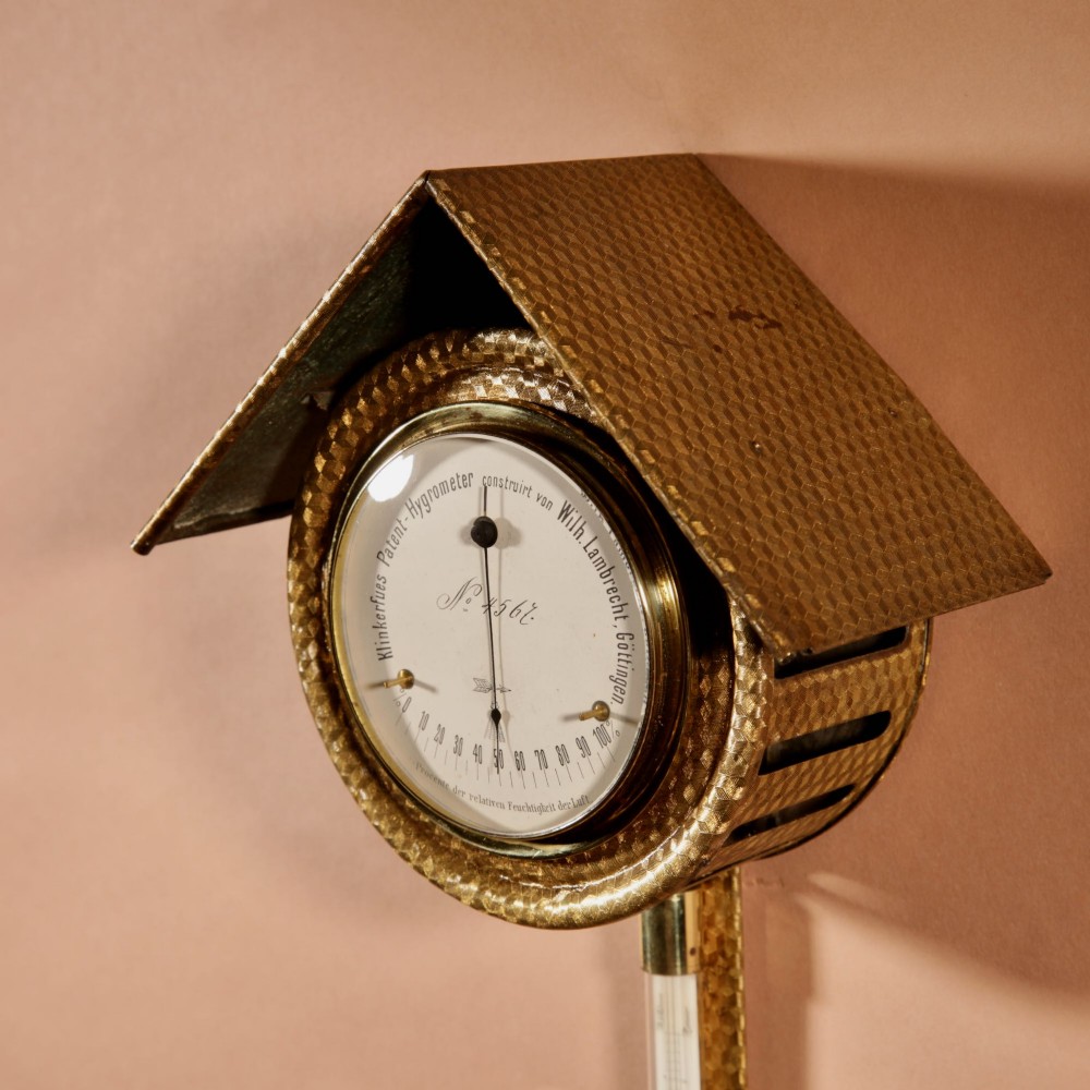 An antique late nineteenth-century brass wall-mounted Klinkerfues patent hair hygrometer weather station featuring two circular dials and a central thermometer tube. View IV