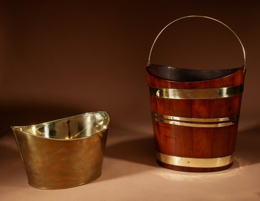A boat-shaped mahogany peat bucket bound with polished brass bands and featuring a looped brass handle and removable brass liner. View VI