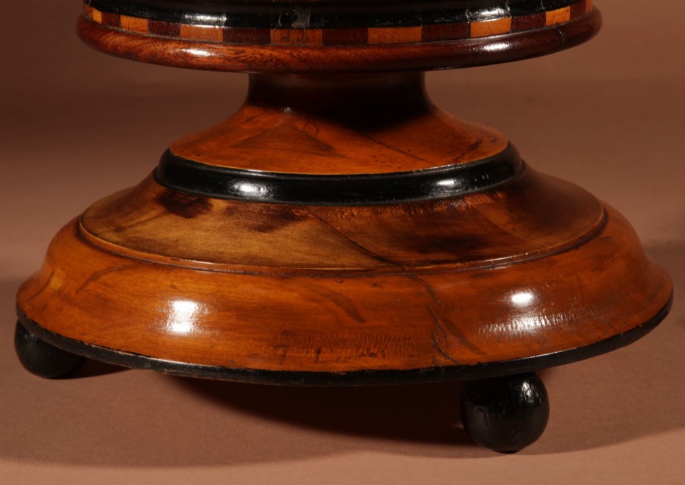 A Dutch coopered wooden peat bucket with alternating brown and ebonised staves, a brass swing handle, and a removable metal liner on a footed pedestal base. View VI
