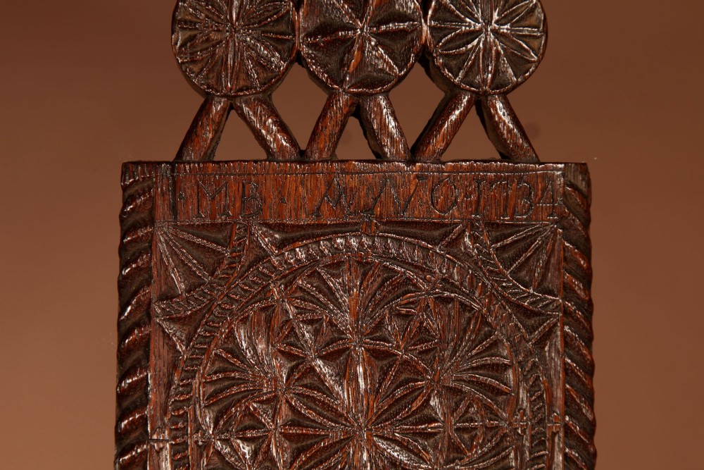 An elongated dark oak Frisian mangle board featuring intricate chip-carved geometric rosettes, carved lettering, dated 1734, and an openwork crest handle. View III