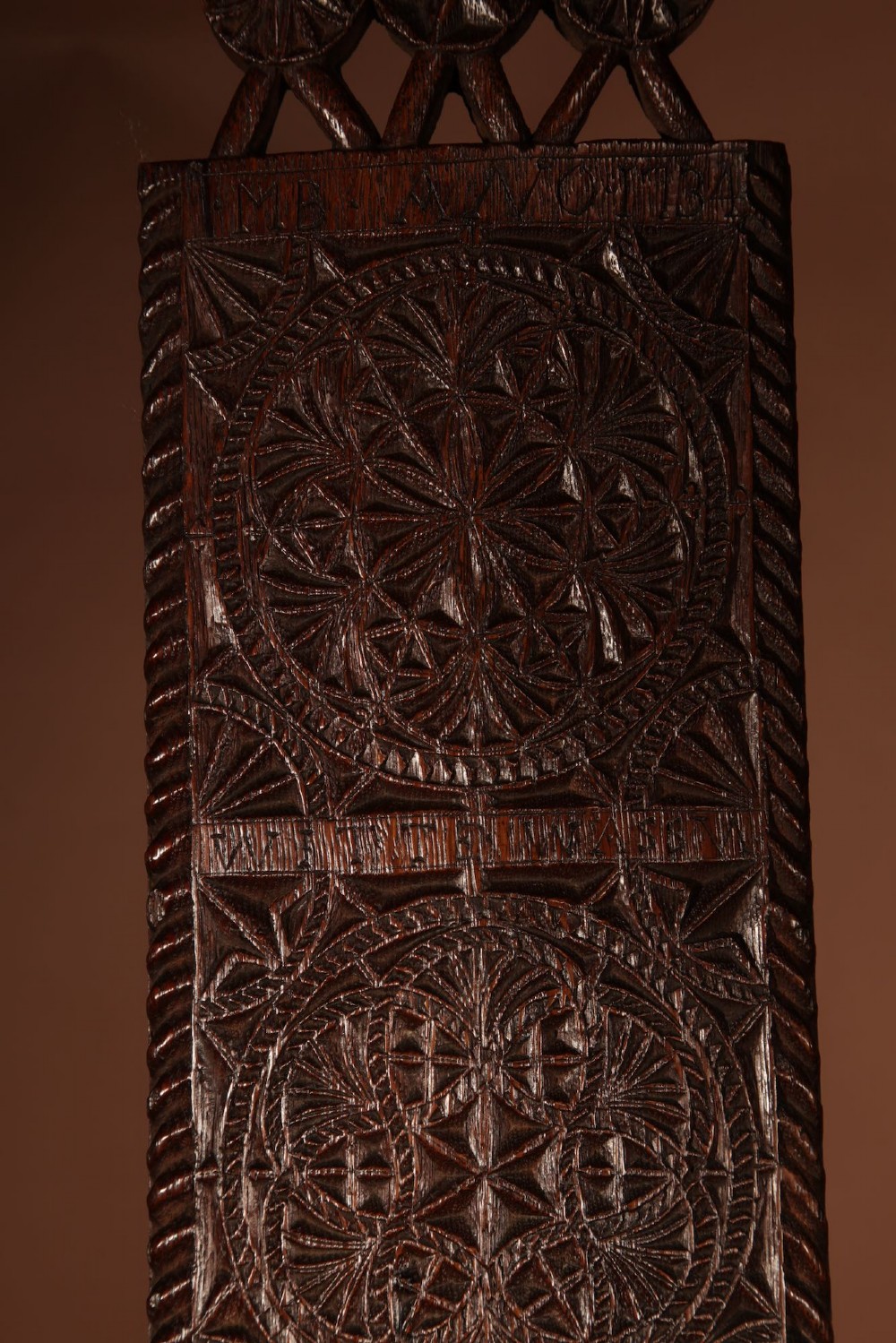 An elongated dark oak Frisian mangle board featuring intricate chip-carved geometric rosettes, carved lettering, dated 1734, and an openwork crest handle. View IV