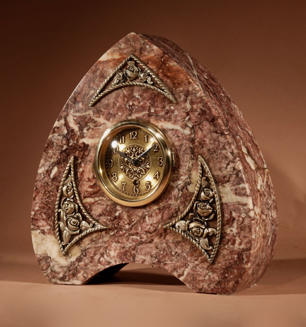 A three-piece French Art Deco clock garniture crafted from veined rose marble with brass floral embellishments and matching side tazzas. View IV