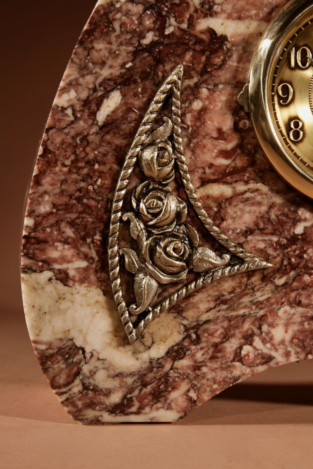 A three-piece French Art Deco clock garniture crafted from veined rose marble with brass floral embellishments and matching side tazzas. View VI
