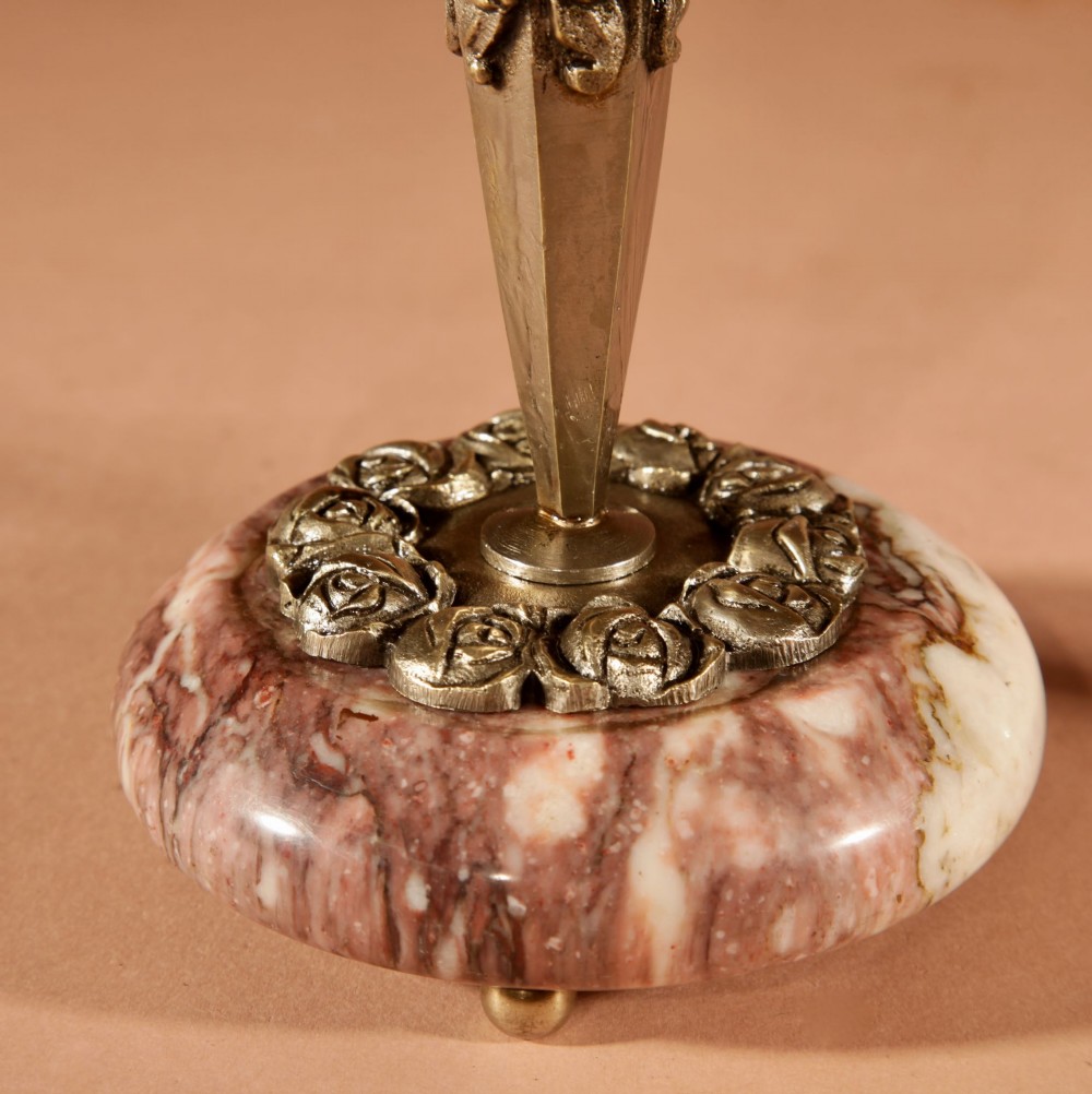 A three-piece French Art Deco clock garniture crafted from veined rose marble with brass floral embellishments and matching side tazzas. View X