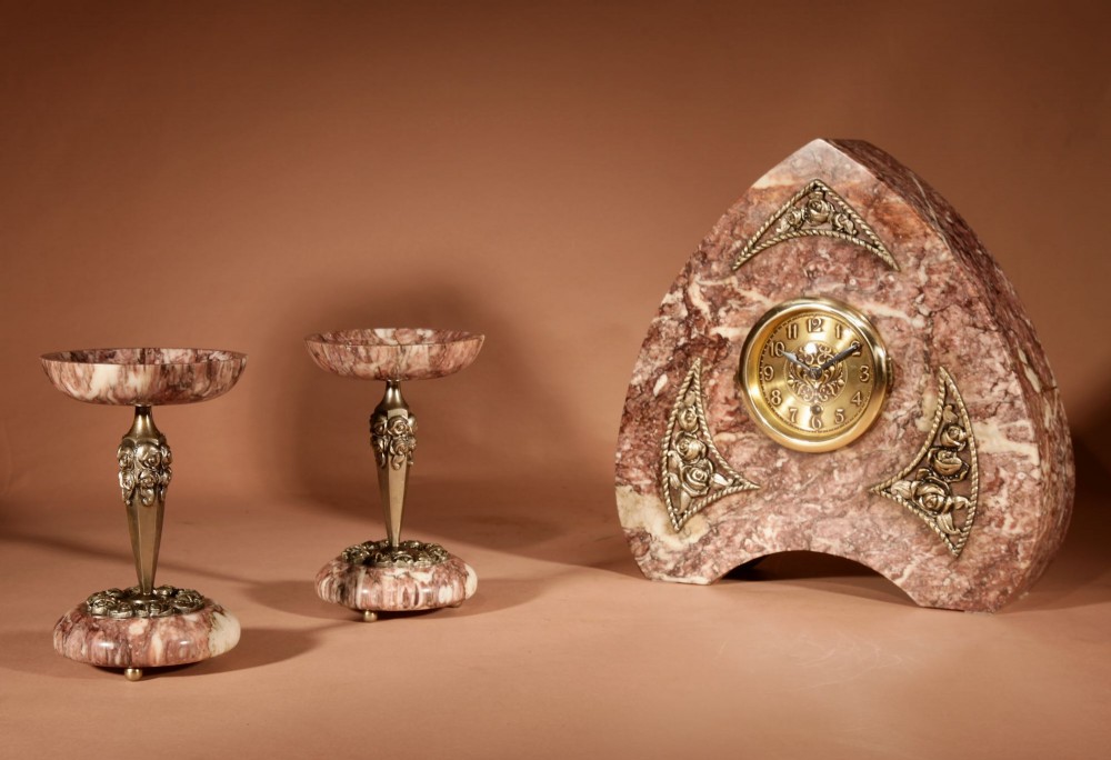 A three-piece French Art Deco clock garniture crafted from veined rose marble with brass floral embellishments and matching side tazzas. View XIII