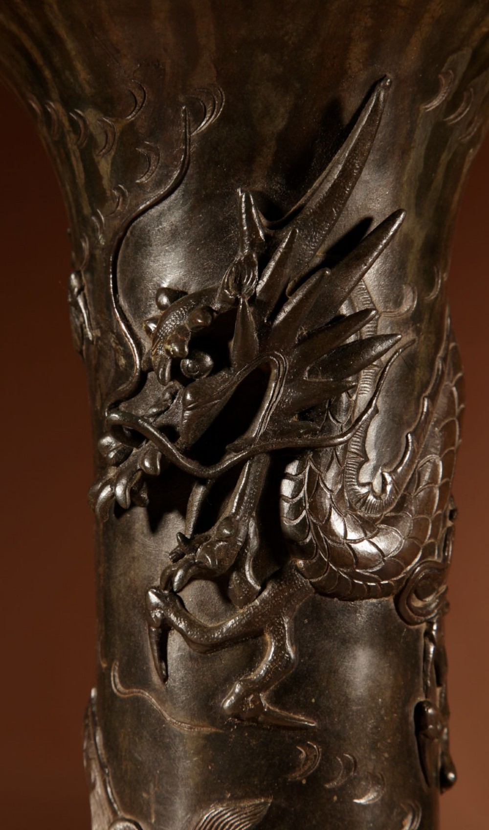 A dark patinated Japanese bronze table lamp featuring a relief-carved dragon wrapped around the central column, topped with a cream pleated lampshade. View III