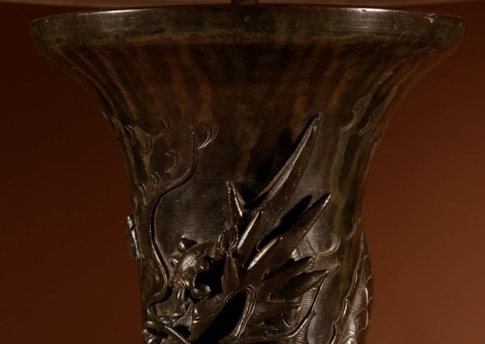 A dark patinated Japanese bronze table lamp featuring a relief-carved dragon wrapped around the central column, topped with a cream pleated lampshade. View IV