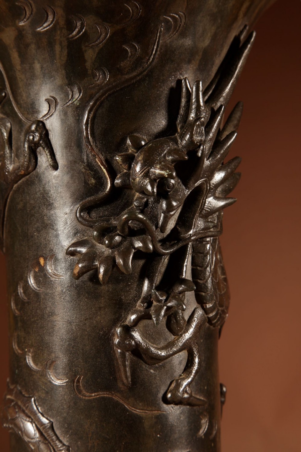 A dark patinated Japanese bronze table lamp featuring a relief-carved dragon wrapped around the central column, topped with a cream pleated lampshade. View V