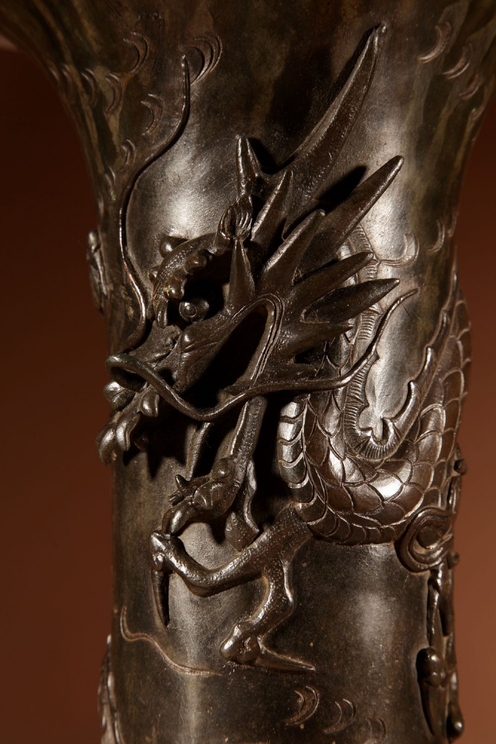 A dark patinated Japanese bronze table lamp featuring a relief-carved dragon wrapped around the central column, topped with a cream pleated lampshade. View VIII