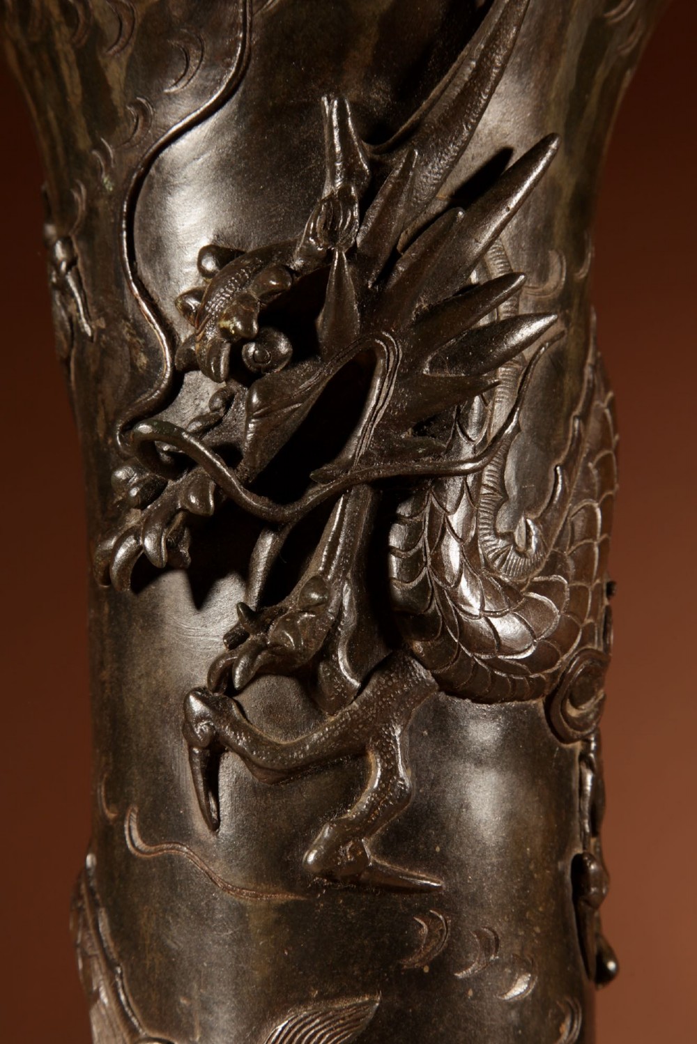 A dark patinated Japanese bronze table lamp featuring a relief-carved dragon wrapped around the central column, topped with a cream pleated lampshade. View IX