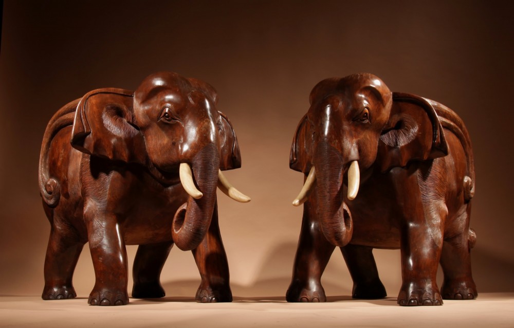 A pair of heavy hand-carved wooden armchairs sculpted in the form of standing elephants with textured hides and light-coloured tusks. View III