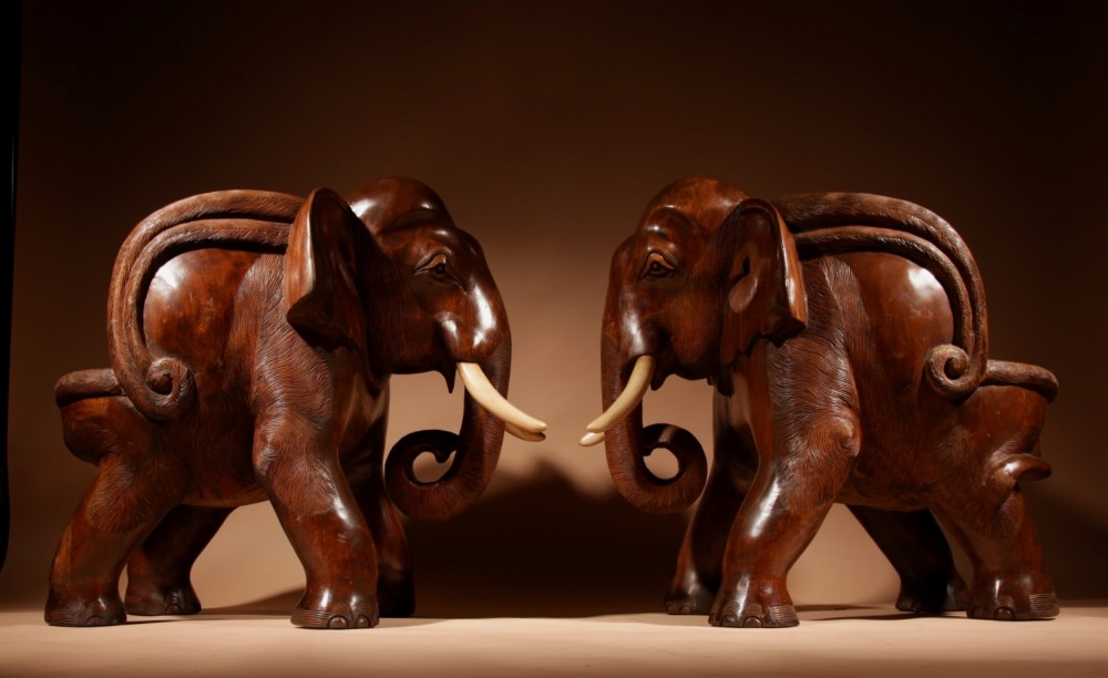 A pair of heavy hand-carved wooden armchairs sculpted in the form of standing elephants with textured hides and light-coloured tusks. View IV
