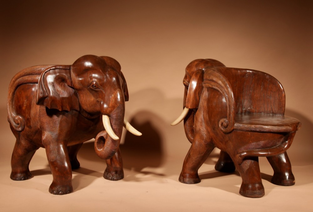 A pair of heavy hand-carved wooden armchairs sculpted in the form of standing elephants with textured hides and light-coloured tusks. View VI