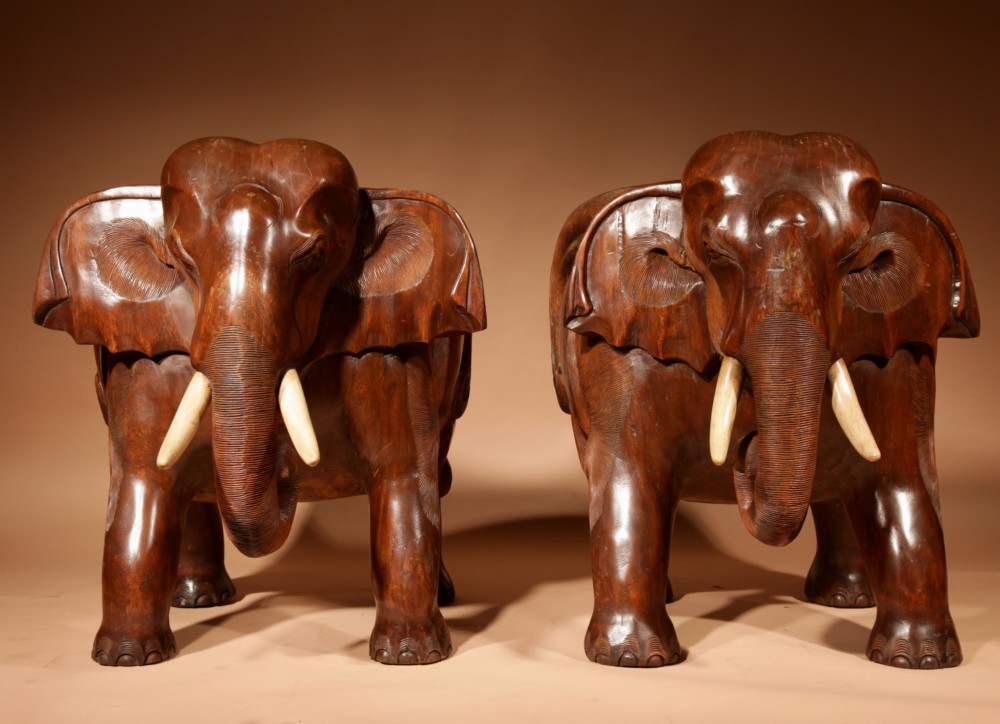 A pair of heavy hand-carved wooden armchairs sculpted in the form of standing elephants with textured hides and light-coloured tusks. View VII