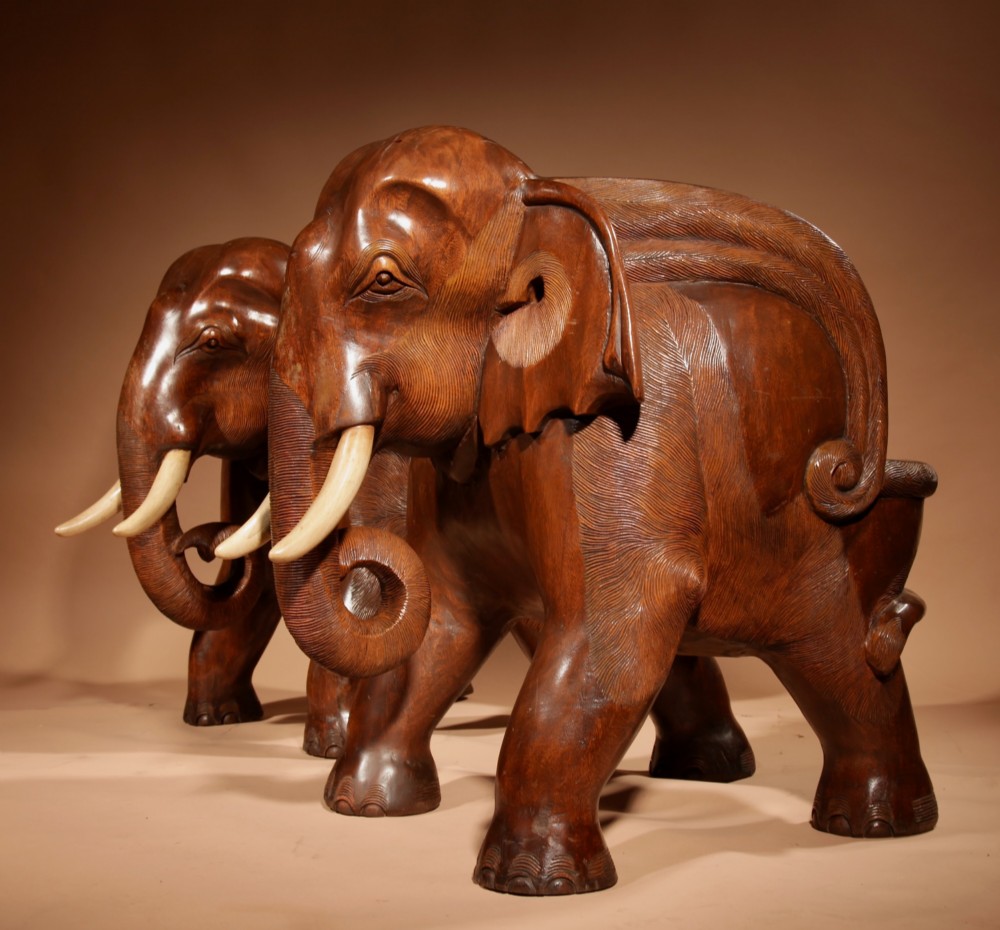 A pair of heavy hand-carved wooden armchairs sculpted in the form of standing elephants with textured hides and light-coloured tusks. View VIII