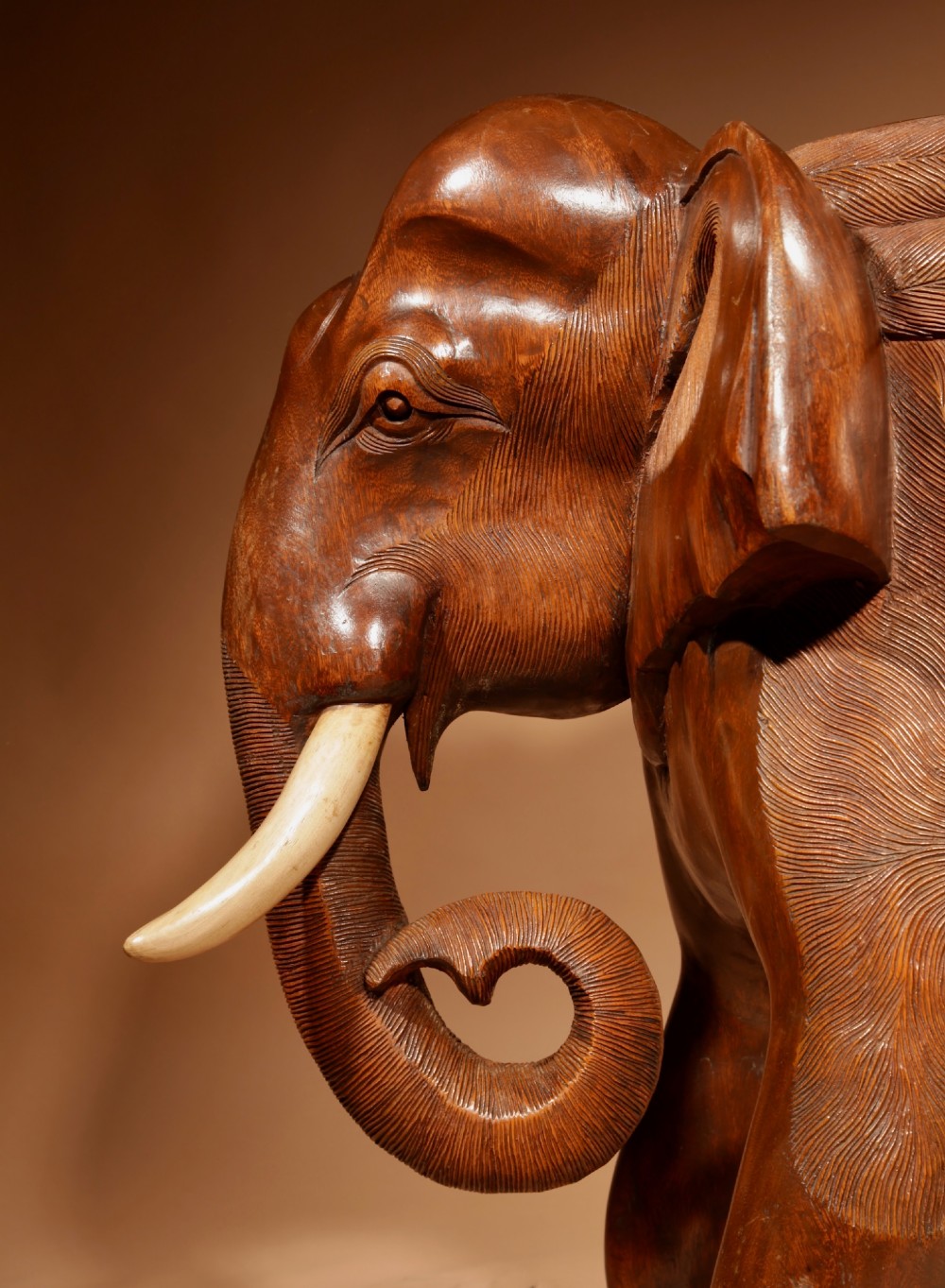 A pair of heavy hand-carved wooden armchairs sculpted in the form of standing elephants with textured hides and light-coloured tusks. View XII