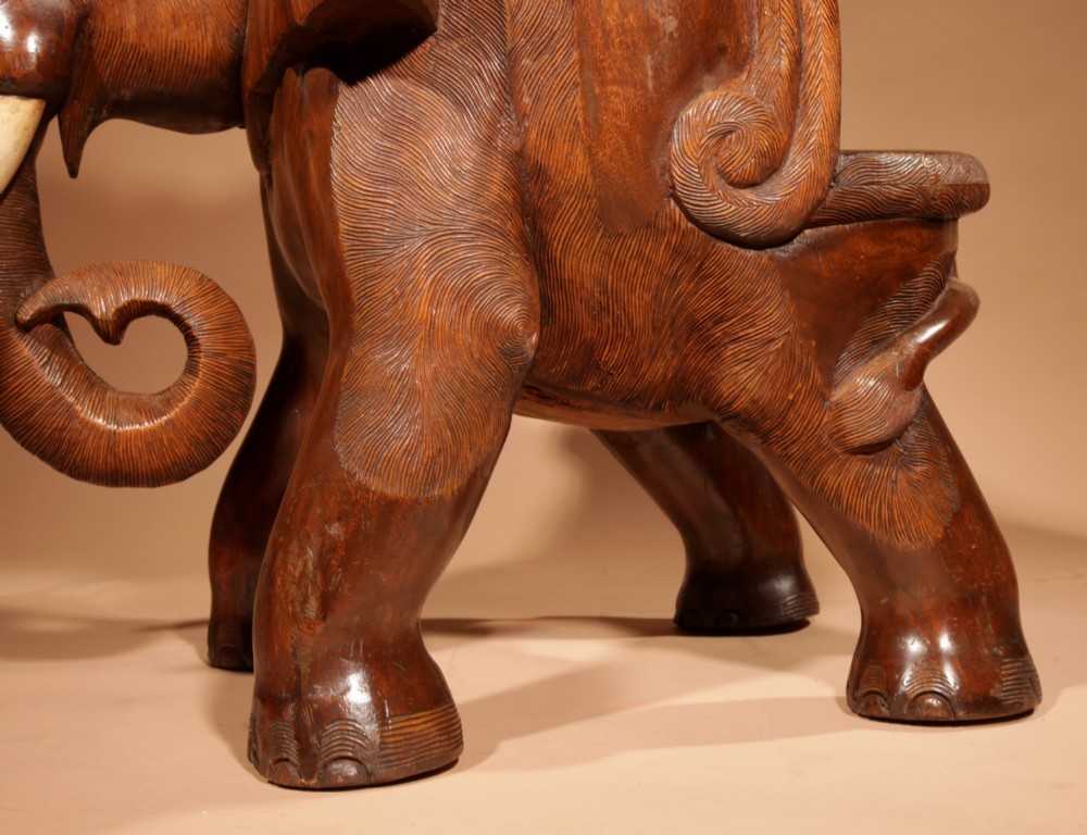 A pair of heavy hand-carved wooden armchairs sculpted in the form of standing elephants with textured hides and light-coloured tusks. View XIII