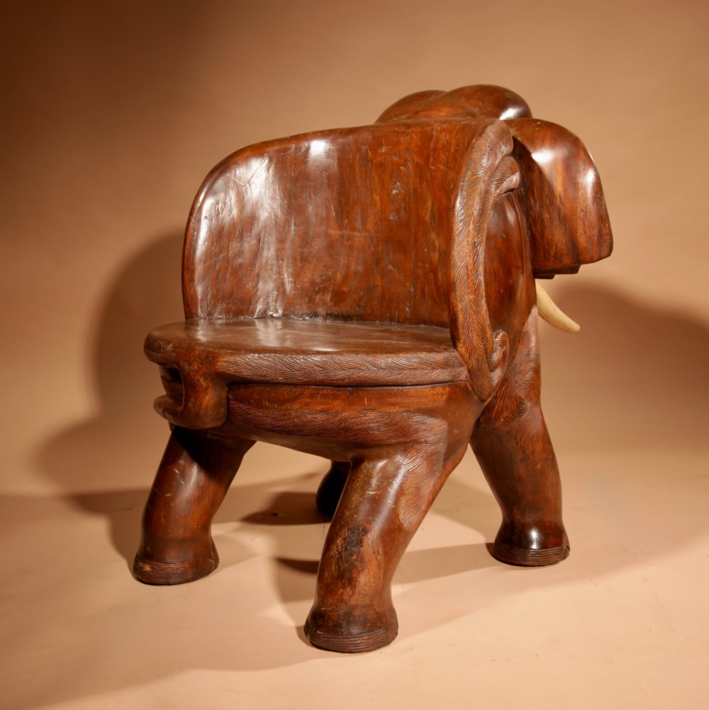 A pair of heavy hand-carved wooden armchairs sculpted in the form of standing elephants with textured hides and light-coloured tusks. View XIV