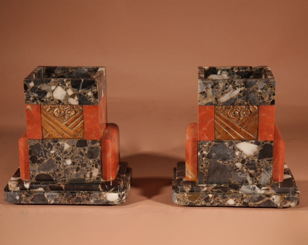 An Art Deco clock garniture set constructed from dark speckled stone and coral marble featuring a central rectangular clock with gilt numerals and two matching side pieces. View VIII