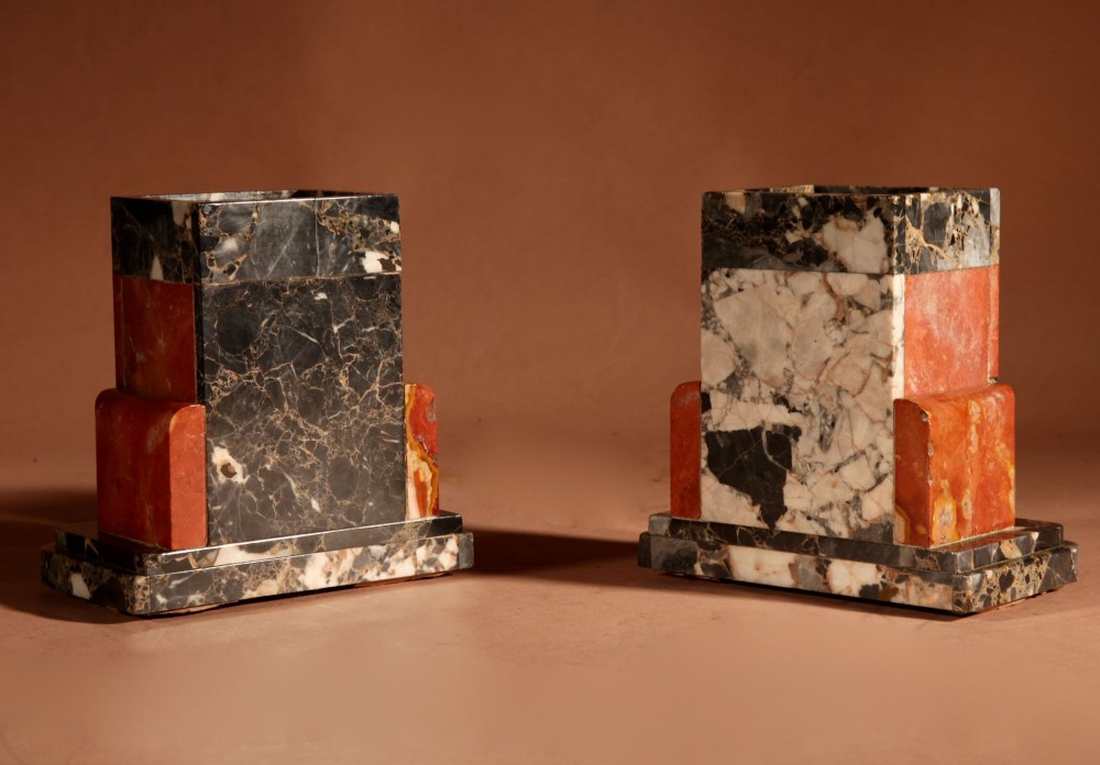 An Art Deco clock garniture set constructed from dark speckled stone and coral marble featuring a central rectangular clock with gilt numerals and two matching side pieces. View XI