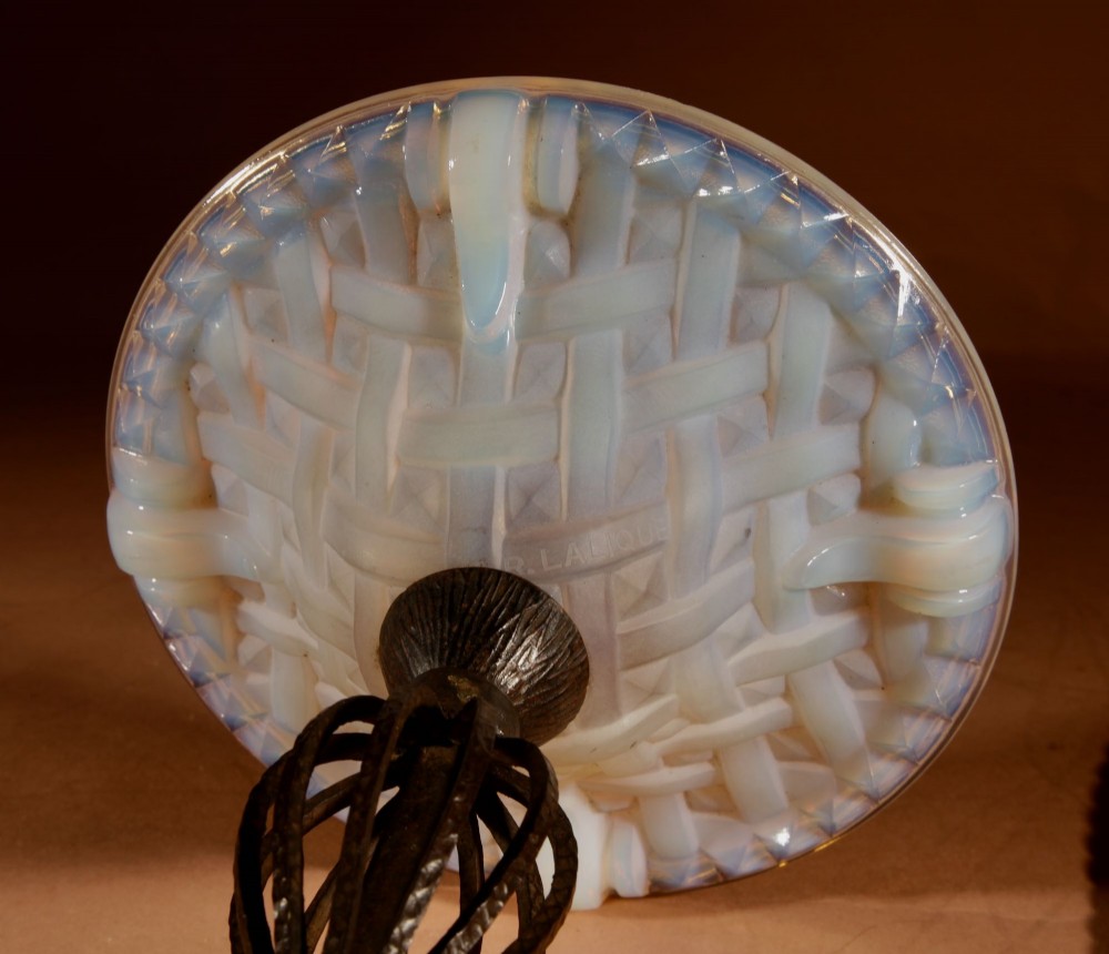 An illuminated French Art Deco table lamp with a flared opalescent glass shade set atop a dark, hammered wrought iron stem and circular base. View VIII