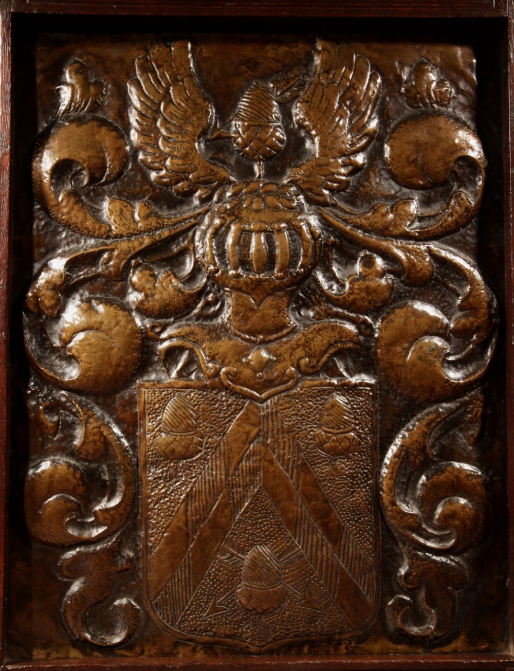 An antique dark oak fire screen featuring a central chased brass panel depicting a coat of arms with an eagle and acorns. View III