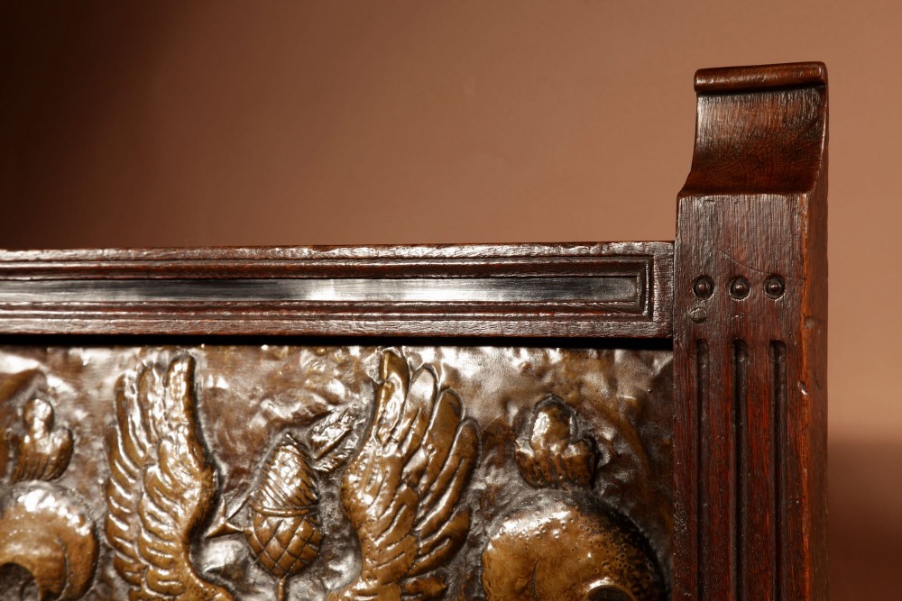 An antique dark oak fire screen featuring a central chased brass panel depicting a coat of arms with an eagle and acorns. View VIII