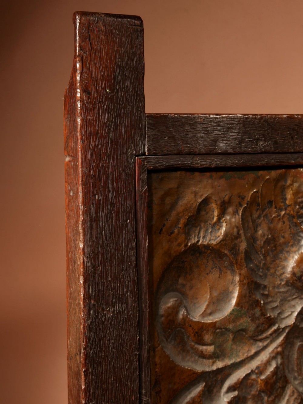 An antique dark oak fire screen featuring a central chased brass panel depicting a coat of arms with an eagle and acorns. View XIII
