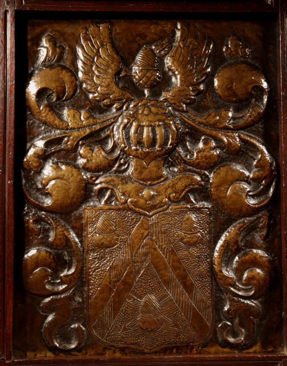 An antique dark oak fire screen featuring a central chased brass panel depicting a coat of arms with an eagle and acorns. View XIV