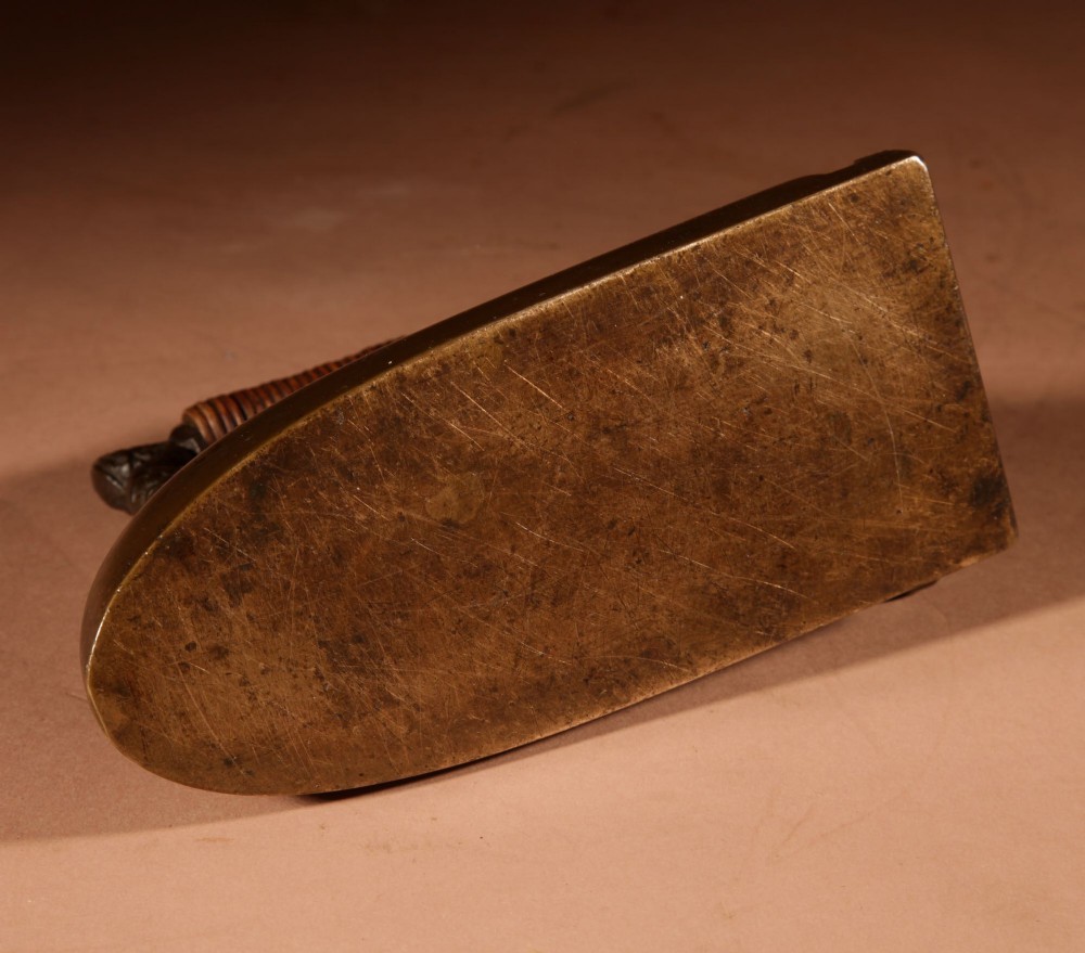 A nineteenth-century French bronze flat iron featuring twin dolphin-shaped supports, a cane-wrapped handle, and a rear door mechanism. View XIV