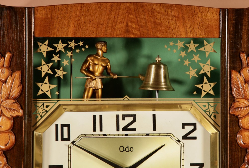 An Art Deco carved walnut wall clock by Odo featuring a brass automaton bell striker and a Venetian glass lower window. View IV