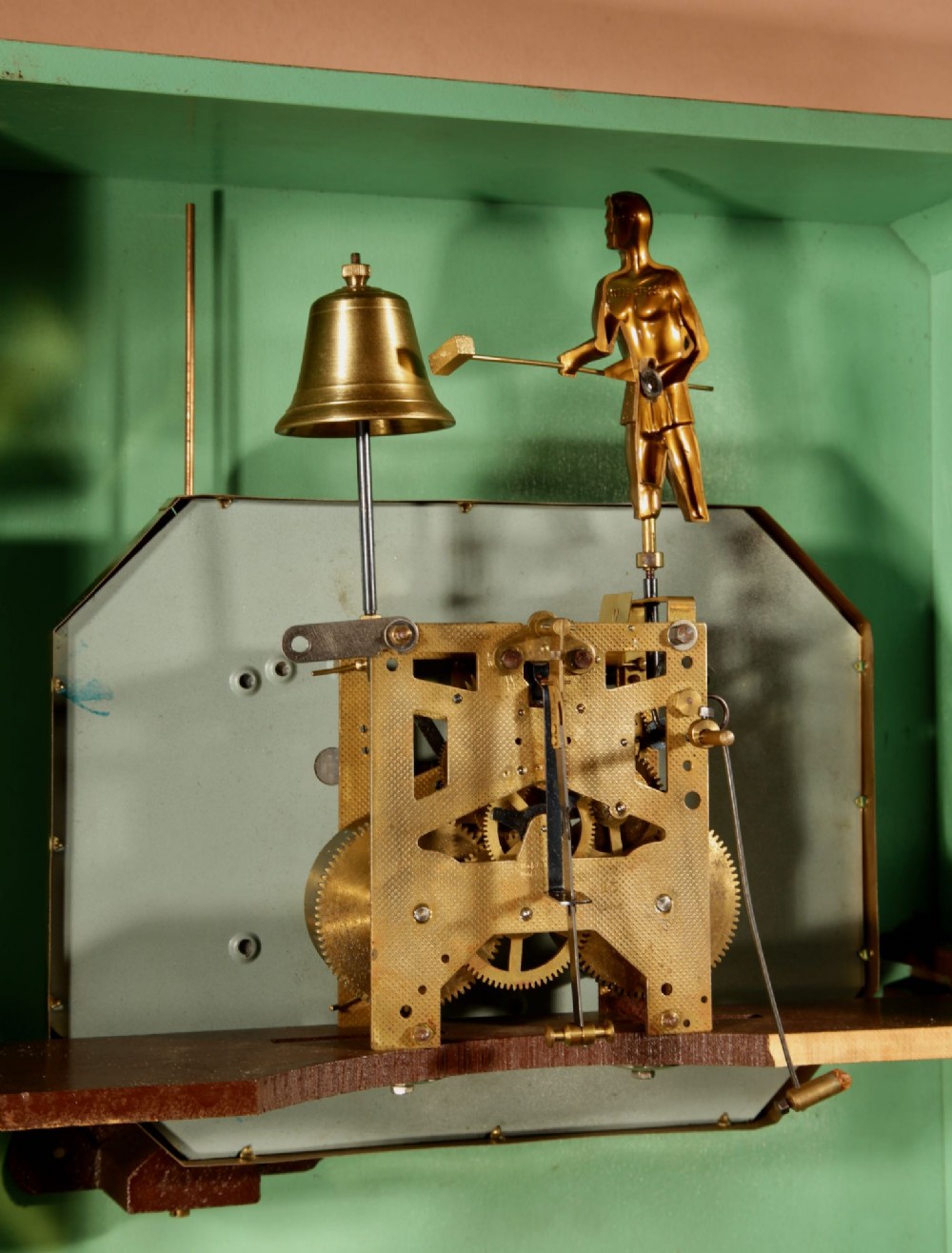 An Art Deco carved walnut wall clock by Odo featuring a brass automaton bell striker and a Venetian glass lower window. View XI