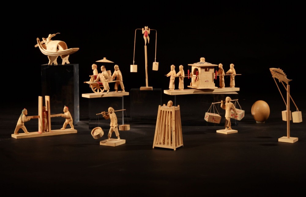 A collection of nine hand-carved light wood miniatures depicting various traditional Chinese daily life trades, vehicles, and activities.