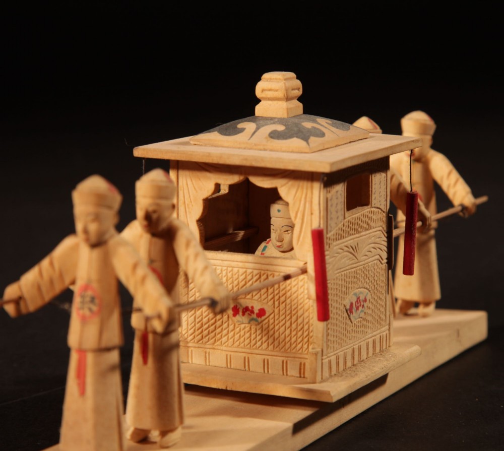 A collection of nine hand-carved light wood miniatures depicting various traditional Chinese daily life trades, vehicles, and activities. View V