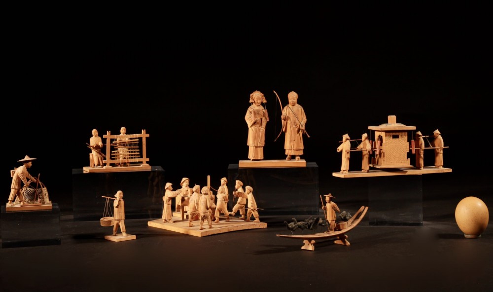 A collection of seven light-coloured Chinese wood carvings depicting figures engaged in traditional daily activities including weaving, fishing, and carrying a sedan chair.