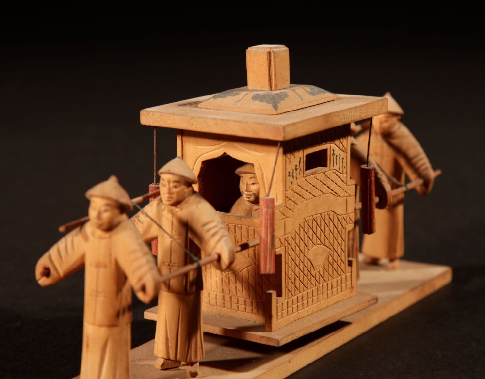 A collection of seven light-coloured Chinese wood carvings depicting figures engaged in traditional daily activities including weaving, fishing, and carrying a sedan chair. View IV