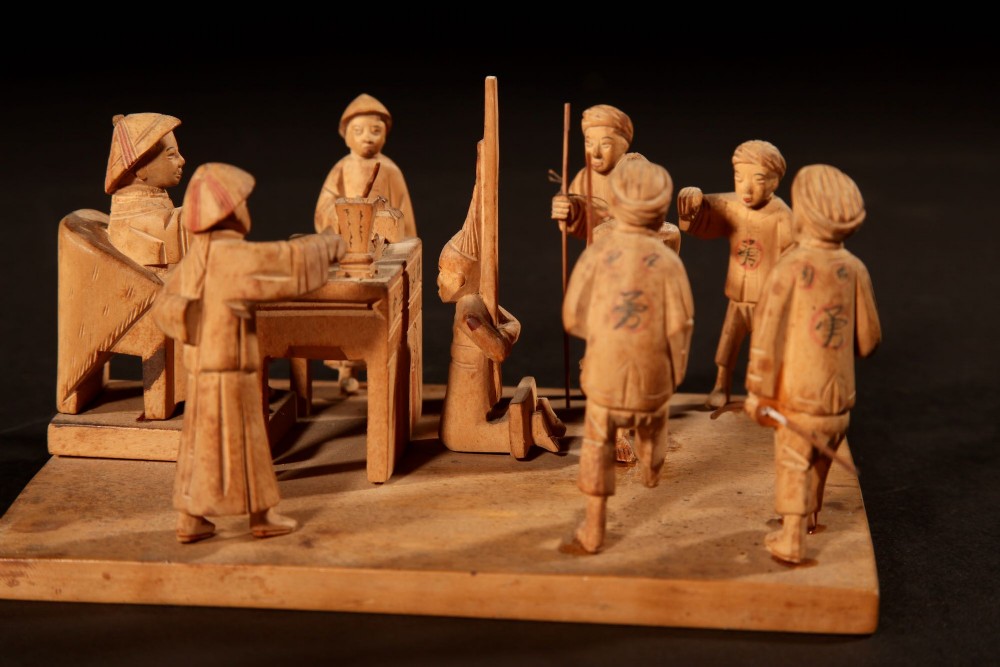 A collection of seven light-coloured Chinese wood carvings depicting figures engaged in traditional daily activities including weaving, fishing, and carrying a sedan chair. View XI