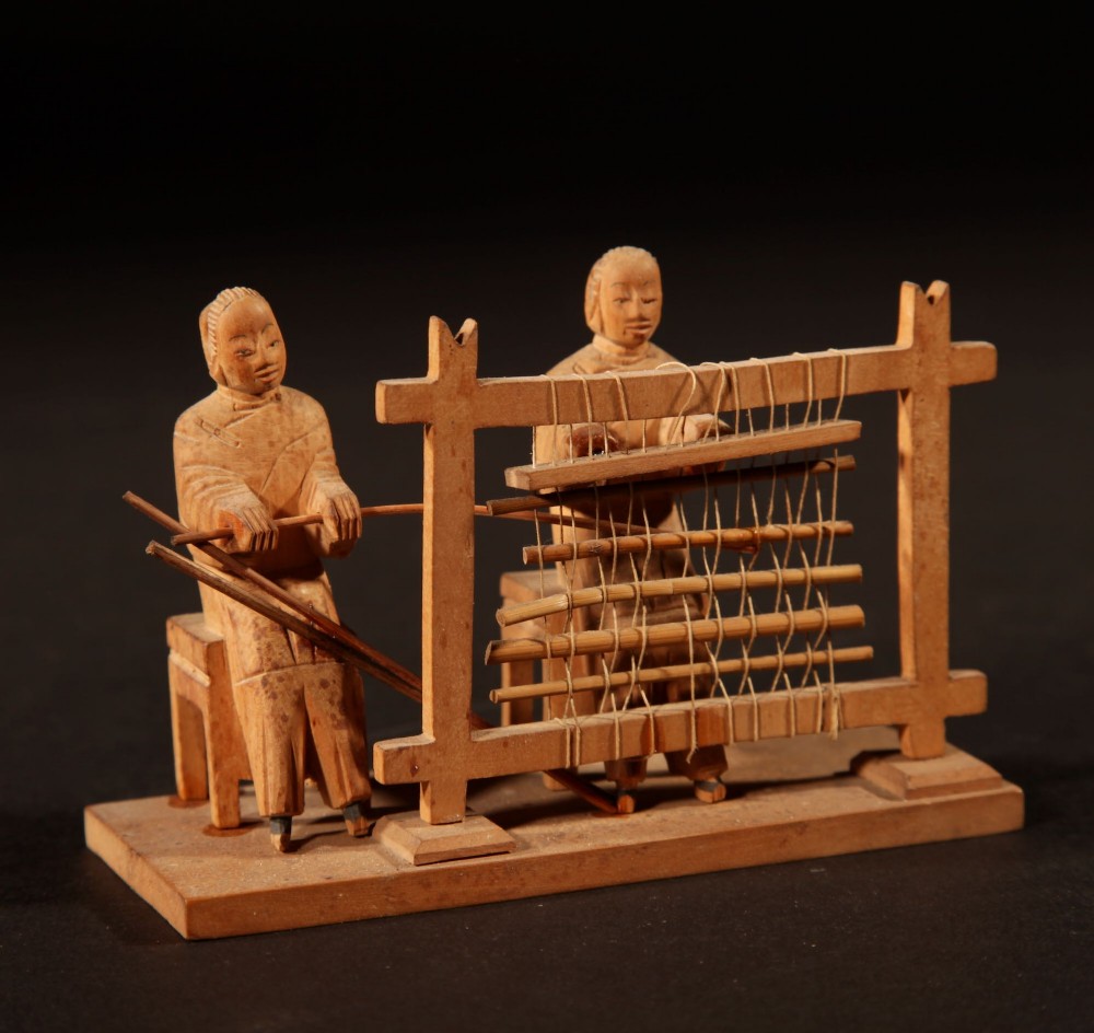 A collection of seven light-coloured Chinese wood carvings depicting figures engaged in traditional daily activities including weaving, fishing, and carrying a sedan chair. View XII